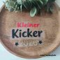 Preview: Hier habe ich das fertig geschnittene Motiv Kleiner Kicker 2026 auf einen Holzteller zusammengelegt.
