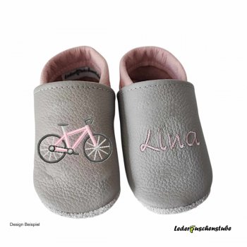 Krabbelschuhe in steingrau-rosa, mit rechts Stickerei Fahrrad (Ramen rosa) und links mittig den Namen rosa
