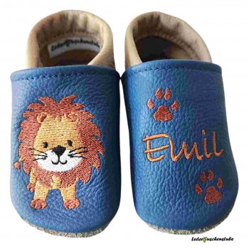 Krabbelschuhe in jeansblau-beige, mit rechts Löwe steht und links Namen (orange) sowie Tatzen (rotbraun)