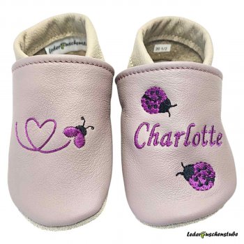 Krabbelschuhe mauve-nude/beige, rechts Käferkleinherz (flieder-schwarz) und links mit Namen (flieder) sowie 2 kleinen Marienkäfern (flieder-schwarz)