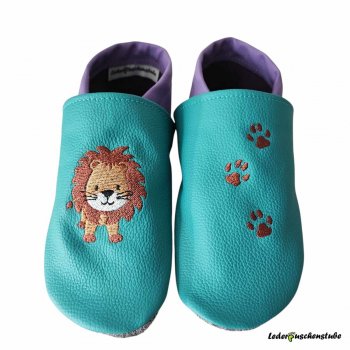 Krabbelschuhe in türkis-lila, mit rechts Löwe steht und links 3 Tatzen (rotbrau)