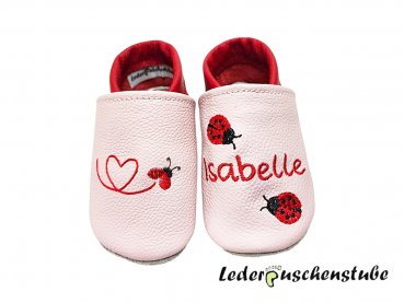 Personalisierte Lederpuschen für Babys mit Namen – Motiv Käferkleinherz und zwei roten Marienkäfern rot-schwarz.