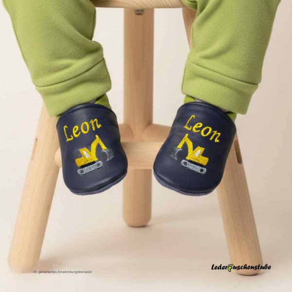 Designbeispiel Krabbelschuhe dunkelblau-hellgrün, mit Namen gelb beiderseits am Spann und Stickerei Bagger gelb