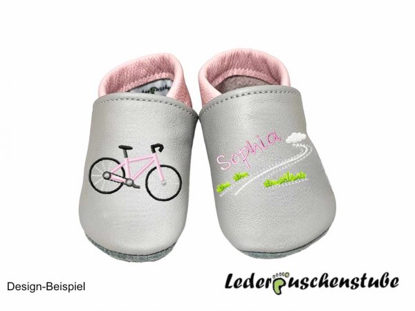 Krabbelschuhe in grau-rosa, mit rechts Stickerei Fahrrad (Ramen rosa) und links mittig den Namen rosa und Straße