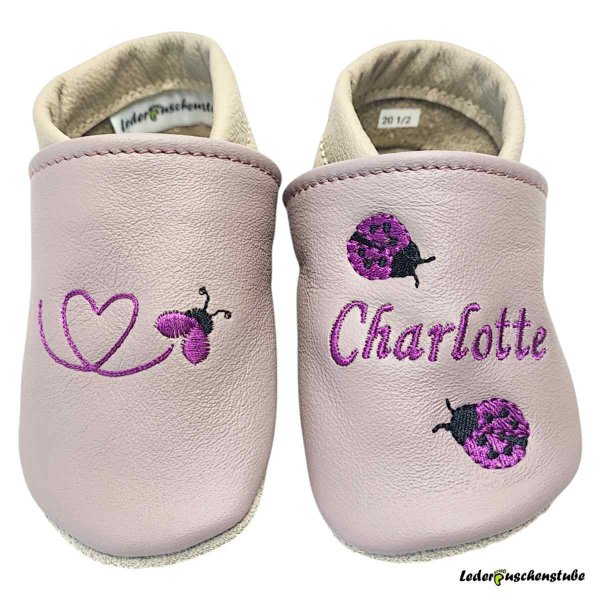 Krabbelschuhe mauve-nude/beige, rechts Käferkleinherz (flieder-schwarz) und links mit Namen (flieder) sowie 2 kleinen Marienkäfern (flieder-schwarz)