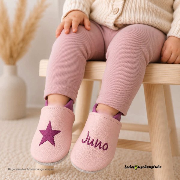 Krabbelschuhe rosa-flieder, rechts Stern flieder und links Name mittig flieder (Hinweis: Das Produktfoto dient als Anwendungsbeispiele und wurden zur Veranschaulichung digital (KI-Mockup) erstellt.