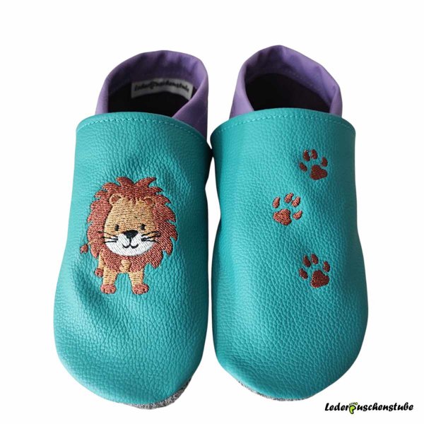 Krabbelschuhe in türkis-lila, mit rechts Löwe steht und links 3 Tatzen (rotbrau)